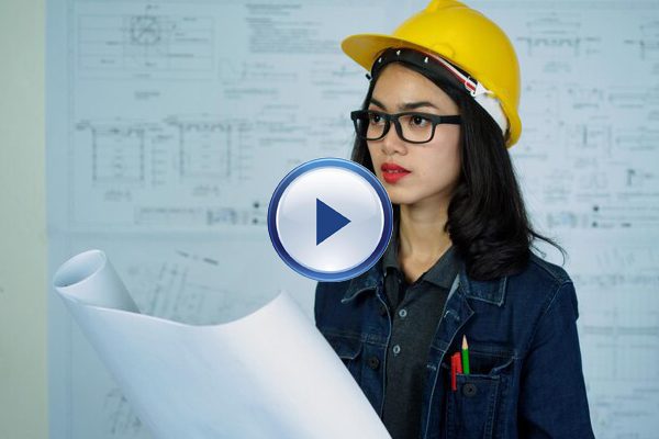 A woman in a hard hat holding papers.